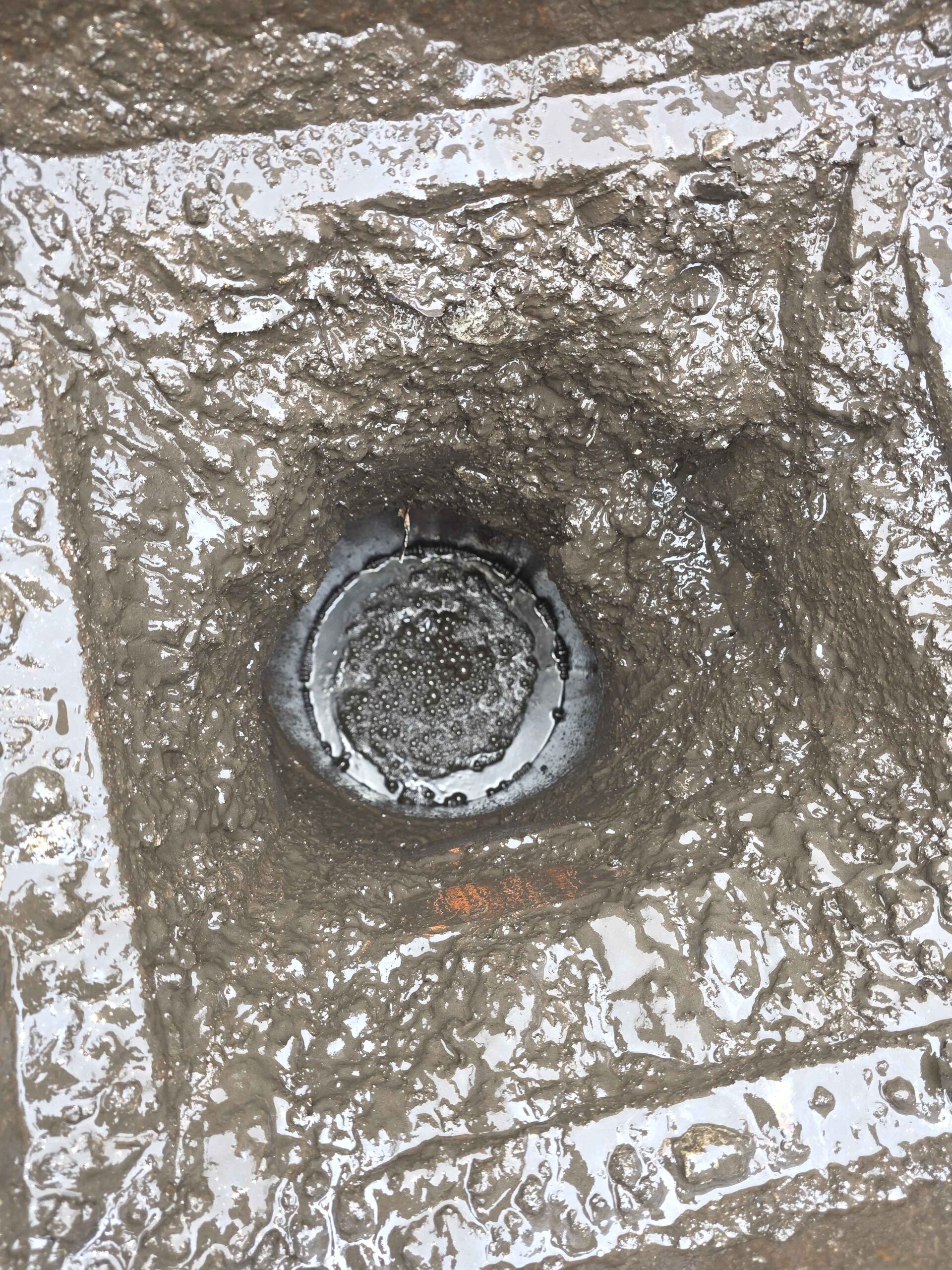 Blocked drain chamber with water bubbling - before clearance