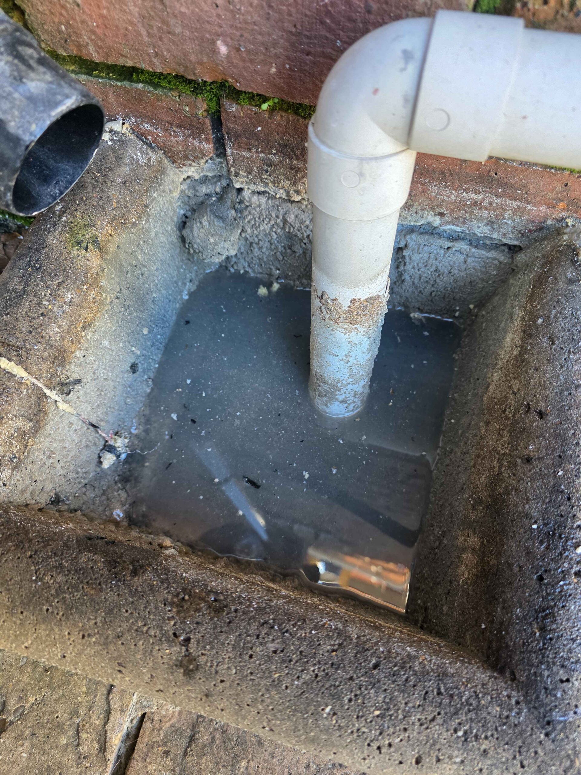 Inspection chamber with standing water and downpipe - drainage issue
